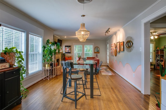 1211 Lansford Ave, Dallas, TX 75224 - dining room with light wood-type flooring, ornamental molding, and a chandelier