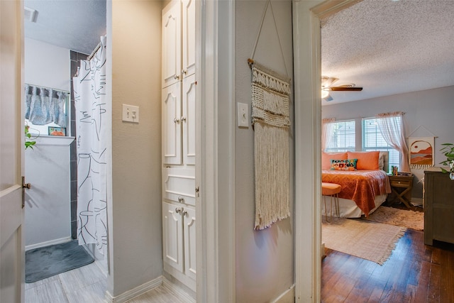 1211 Lansford Ave, Dallas, TX 75224 - full bath with a textured ceiling, wood finished floors, a ceiling fan, and a shower with shower curtain