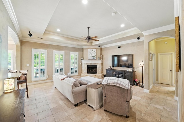 5820 Shiloh Forest Dr, Midlothian, TX 76065 - living area featuring ceiling fan, arched walkways, a tray ceiling, ornamental molding, and a fireplace