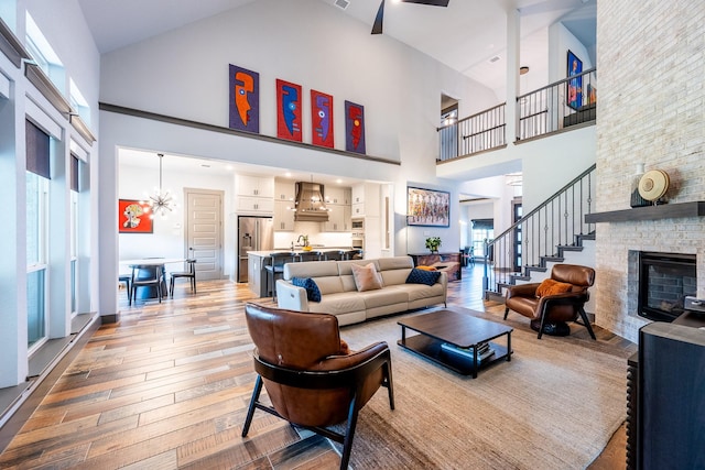 9901 Mi Tierra Dr, Fort Worth, TX 76179 - living room featuring high vaulted ceiling, hardwood / wood-style floors, a stone fireplace, and stairway
