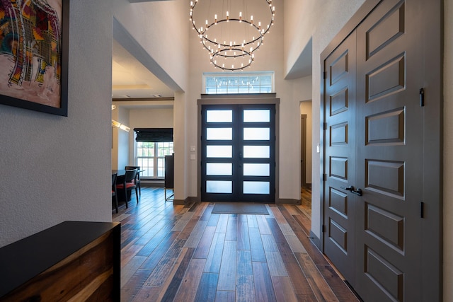 9901 Mi Tierra Dr, Fort Worth, TX 76179 - entryway with a chandelier, dark wood-style flooring, a towering ceiling, and a textured wall