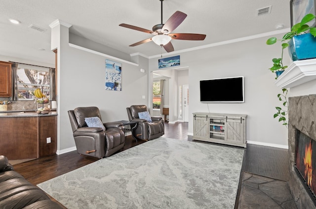 1617 Shadywood Ln, Flower Mound, TX 75028 - living room featuring a ceiling fan, plenty of natural light, a warm lit fireplace, crown molding, and dark wood-type flooring