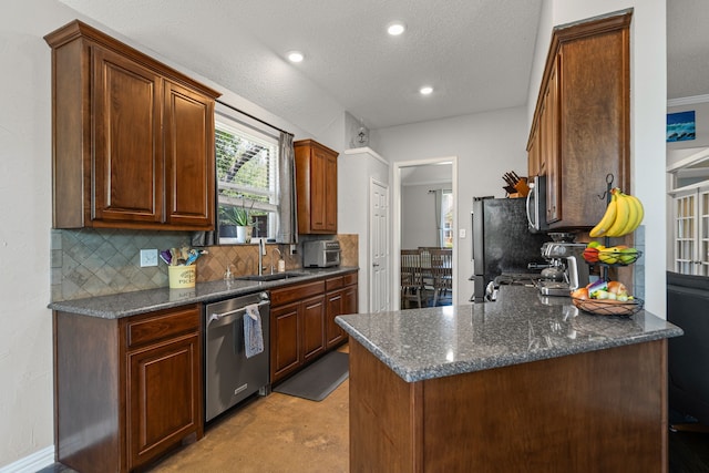 1617 Shadywood Ln, Flower Mound, TX 75028 - kitchen featuring stainless steel appliances, backsplash, a textured ceiling, recessed lighting, and a peninsula