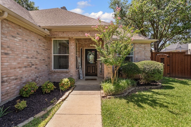 1617 Shadywood Ln, Flower Mound, TX 75028 - view of exterior entry featuring brick siding, a shingled roof, and a gate