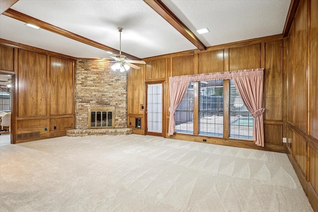 4120 Merriman Dr, Plano, TX 75074 - unfurnished living room with wooden walls, beamed ceiling, light colored carpet, ceiling fan, and a brick fireplace
