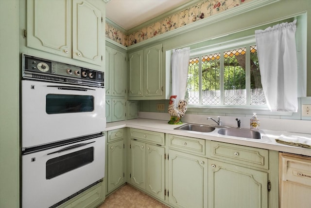 1008 Dobbins Rd, Corsicana, TX 75110 - kitchen featuring white double oven, dishwasher, light countertops, green cabinetry, and ornamental molding