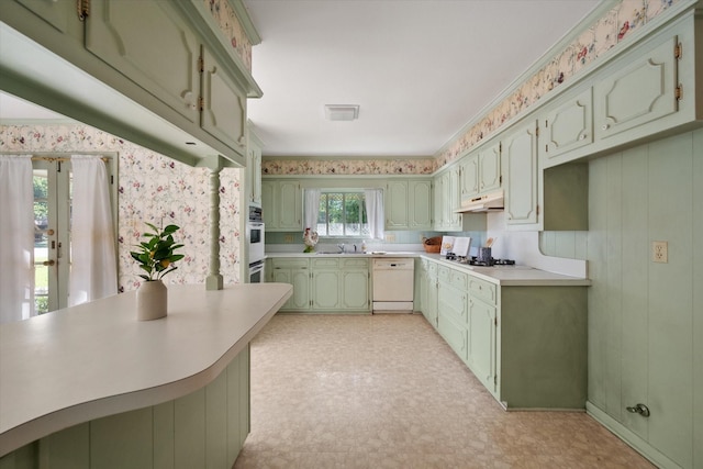 1008 Dobbins Rd, Corsicana, TX 75110 - kitchen with green cabinets, white appliances, light flooring, under cabinet range hood, and light countertops