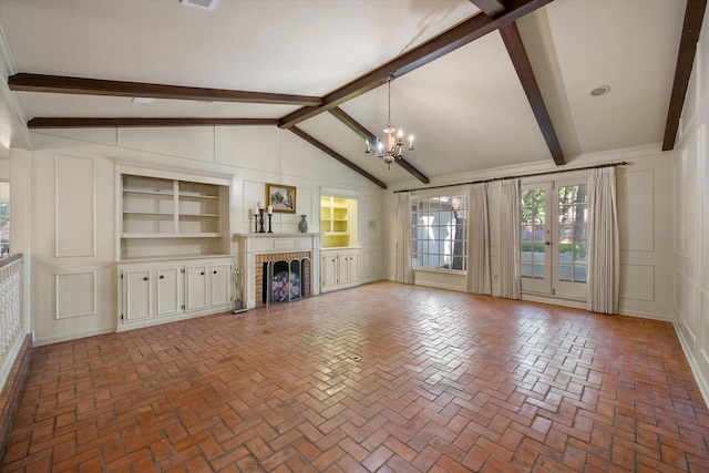1008 Dobbins Rd, Corsicana, TX 75110 - unfurnished living room featuring a chandelier, a brick fireplace, brick flooring, built in shelves, and a decorative wall