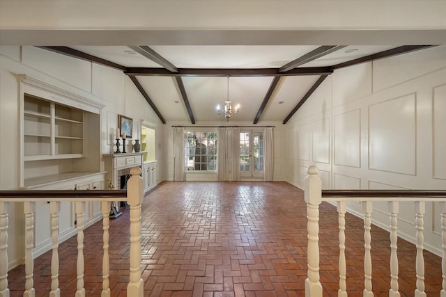 1008 Dobbins Rd, Corsicana, TX 75110 - unfurnished living room featuring a decorative wall, a chandelier, brick floors, and a fireplace