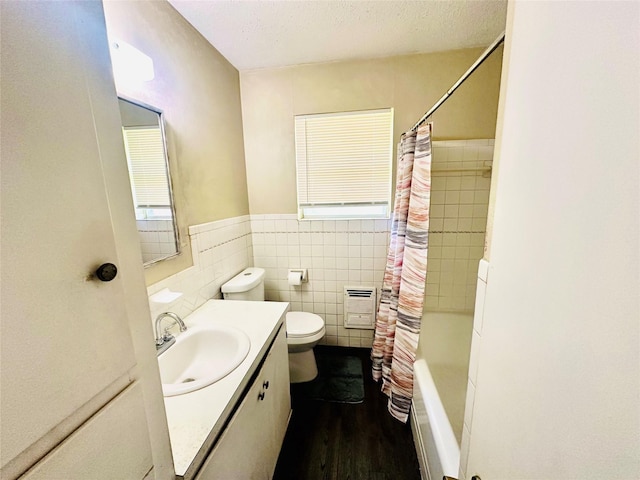 1220 Crestview Dr, Kaufman, TX 75142 - bathroom featuring wood finished floors, tile walls, vanity, shower / bath combo with shower curtain, and a wainscoted wall