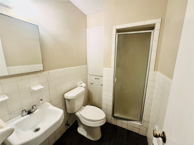 1220 Crestview Dr, Kaufman, TX 75142 - bathroom featuring tile walls, a stall shower, wainscoting, wood finished floors, and a textured ceiling