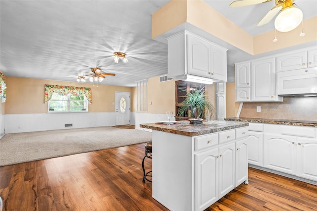 1748 Old Southmayd Rd, Sherman, TX 75092 - kitchen featuring a ceiling fan, white microwave, open floor plan, wainscoting, and wood finished floors