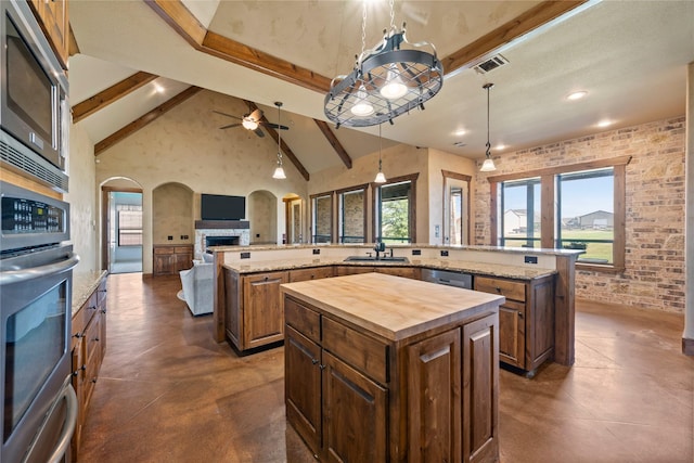 13431 Kira Ln, Justin, TX 76247 - kitchen with a spacious island, arched walkways, stainless steel appliances, butcher block counters, and open floor plan