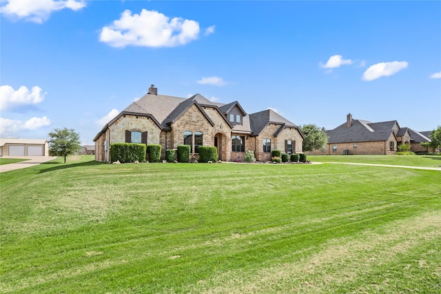 13431 Kira Ln, Justin, TX 76247 - french country style house featuring a front yard, stone siding, brick siding, and a chimney