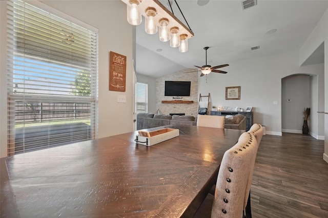 1000 Barn Owl Dr, Little Elm, TX 75068 - dining room with arched walkways, a ceiling fan, a fireplace, lofted ceiling, and dark wood finished floors