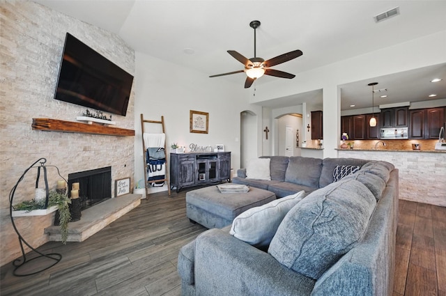 1000 Barn Owl Dr, Little Elm, TX 75068 - living room featuring dark wood-style floors, a ceiling fan, a fireplace, and arched walkways
