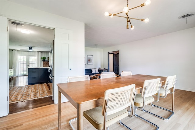 2528 Royal Ln, Denton, TX 76209 - dining area with a chandelier, light wood finished floors, and a ceiling fan