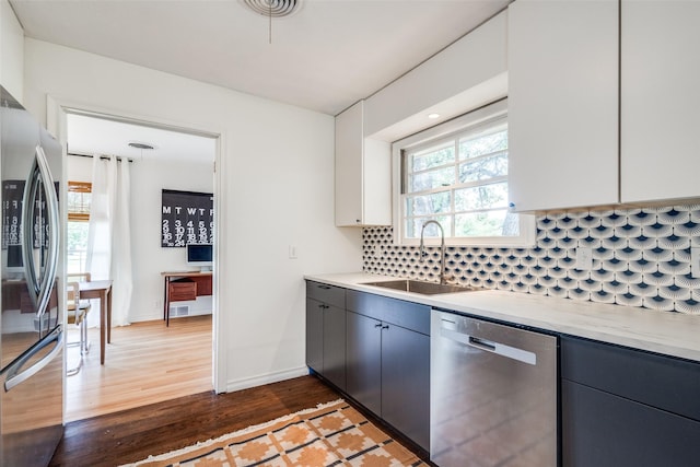 2528 Royal Ln, Denton, TX 76209 - kitchen featuring appliances with stainless steel finishes, light countertops, wood finished floors, and backsplash