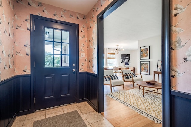 2528 Royal Ln, Denton, TX 76209 - doorway featuring wainscoting, light tile patterned flooring, and a chandelier