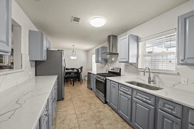 2648 Mark Dr, Mesquite, TX 75150 - kitchen with stainless steel appliances, wall chimney range hood, gray cabinetry, plenty of natural light, and a textured ceiling