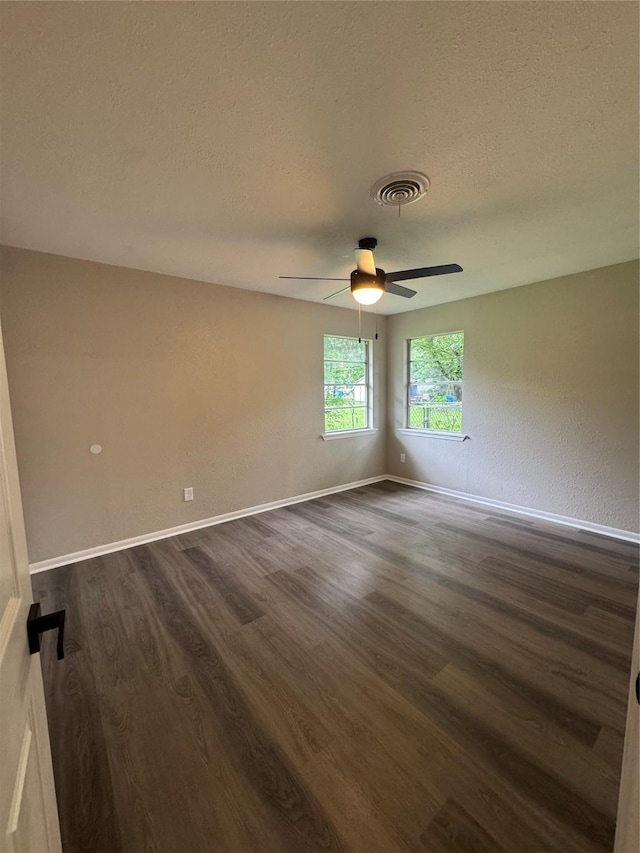 2410 W Collin St, Corsicana, TX 75110 - spare room with dark wood-style flooring, ceiling fan, and a textured ceiling