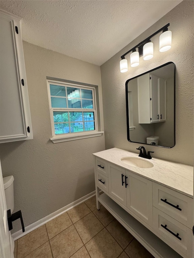 2410 W Collin St, Corsicana, TX 75110 - bathroom featuring a textured ceiling, vanity, and tile patterned flooring
