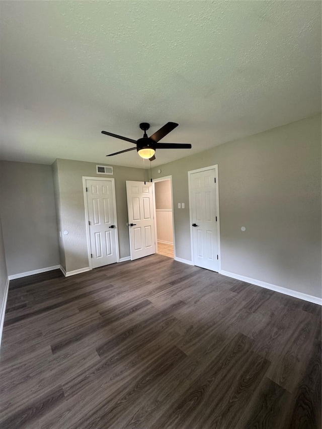 2410 W Collin St, Corsicana, TX 75110 - unfurnished bedroom with dark wood-type flooring, a closet, a textured ceiling, and ceiling fan