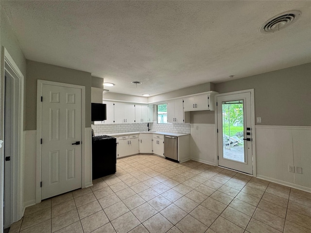 2410 W Collin St, Corsicana, TX 75110 - kitchen with range, dishwasher, light tile patterned floors, light countertops, and a textured ceiling