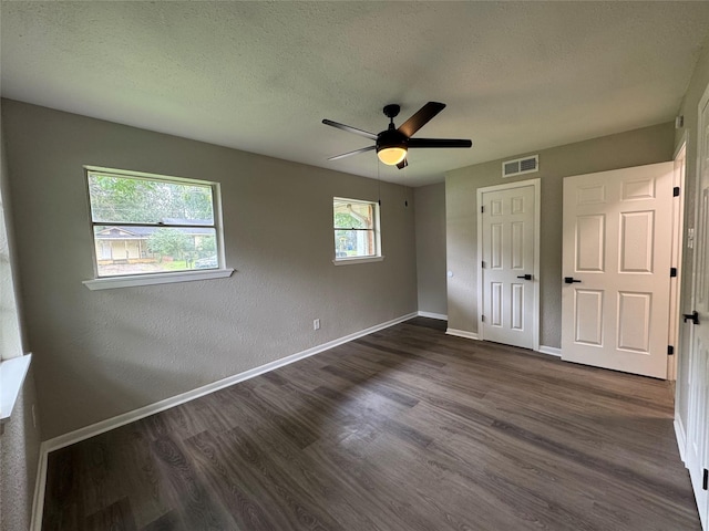 2410 W Collin St, Corsicana, TX 75110 - unfurnished bedroom featuring dark wood-type flooring, a closet, a textured ceiling, and ceiling fan