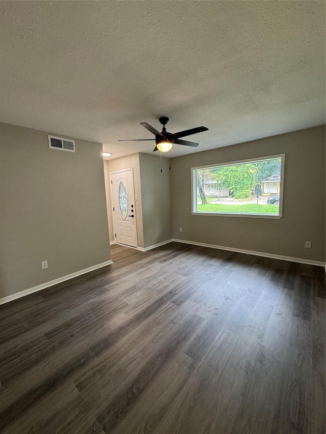 2410 W Collin St, Corsicana, TX 75110 - unfurnished room with a textured ceiling, dark wood finished floors, and a ceiling fan