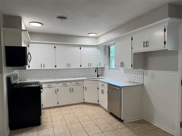 2410 W Collin St, Corsicana, TX 75110 - kitchen with stainless steel appliances, tasteful backsplash, light countertops, light tile patterned floors, and white cabinets