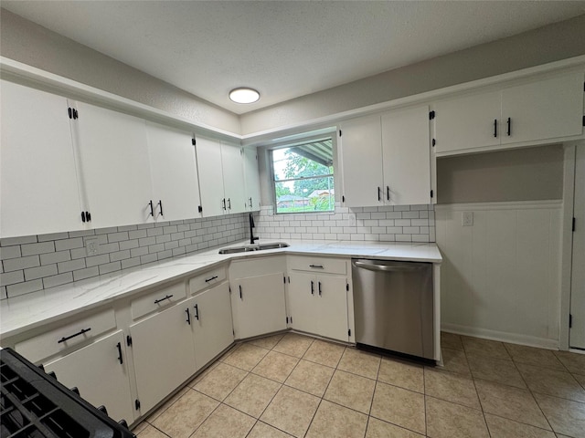 2410 W Collin St, Corsicana, TX 75110 - kitchen with stainless steel dishwasher, decorative backsplash, white cabinets, light tile patterned flooring, and a textured ceiling