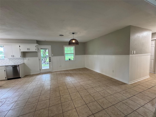 2410 W Collin St, Corsicana, TX 75110 - unfurnished dining area with a wainscoted wall and light tile patterned flooring