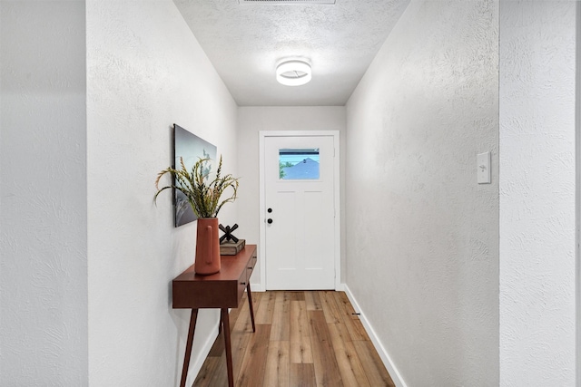 7116 Chapman Dr, North Richland Hills, TX 76182 - entryway featuring light wood-type flooring, a textured wall, and a textured ceiling