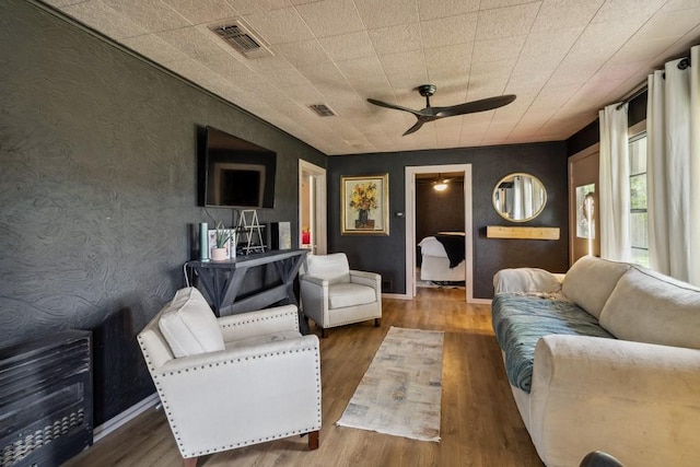 601 E San Saba St, Wortham, TX 76693 - living area featuring ceiling fan, wood finished floors, and wallpapered walls