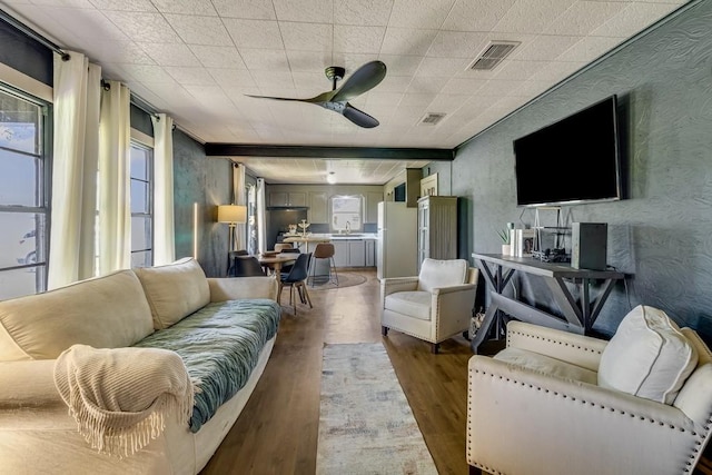 601 E San Saba St, Wortham, TX 76693 - living room featuring wood finished floors, a ceiling fan, and healthy amount of natural light