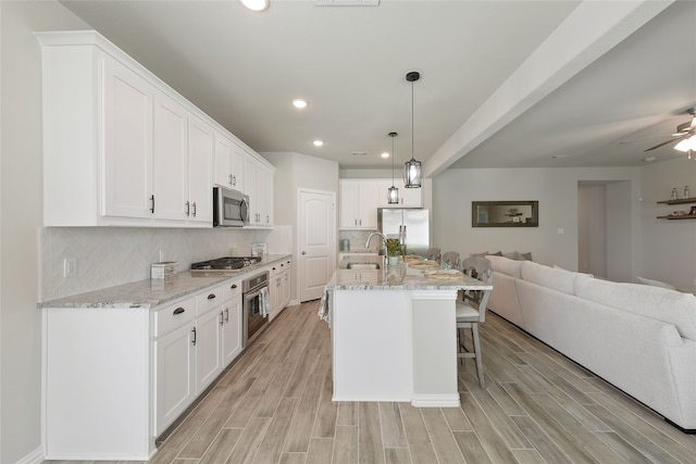 1420 Whitetail Ln, Azle, TX 76020 - kitchen featuring stainless steel appliances, open floor plan, light wood-type flooring, a kitchen breakfast bar, and recessed lighting