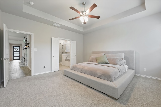 1420 Whitetail Ln, Azle, TX 76020 - carpeted bedroom featuring a tray ceiling, ceiling fan, and ensuite bath