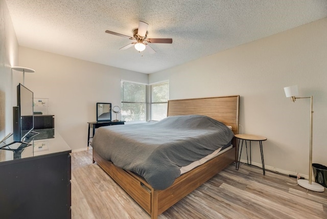 1833 Alonsdale Dr, Garland, TX 75040 - bedroom featuring a textured ceiling, light wood-type flooring, and ceiling fan