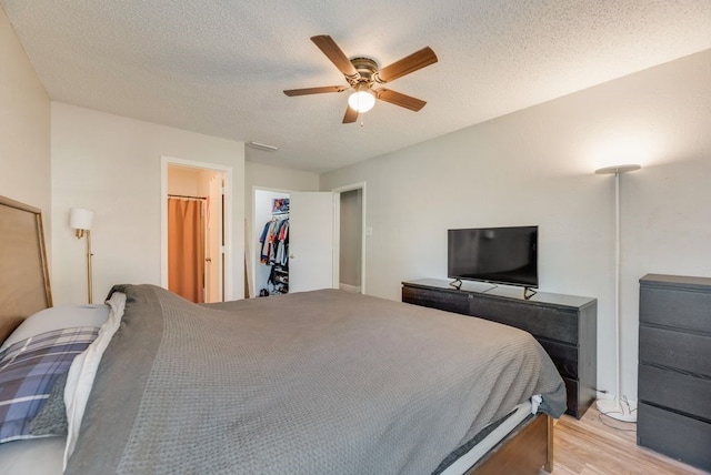 1833 Alonsdale Dr, Garland, TX 75040 - bedroom featuring light wood finished floors, ceiling fan, a textured ceiling, and a closet