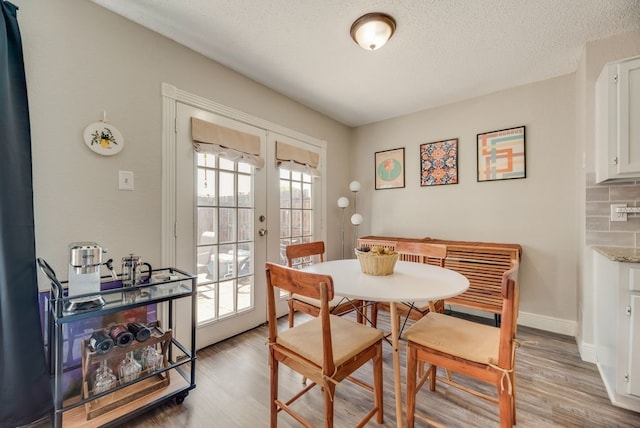 1833 Alonsdale Dr, Garland, TX 75040 - dining space featuring light wood-style flooring, a textured ceiling, and french doors