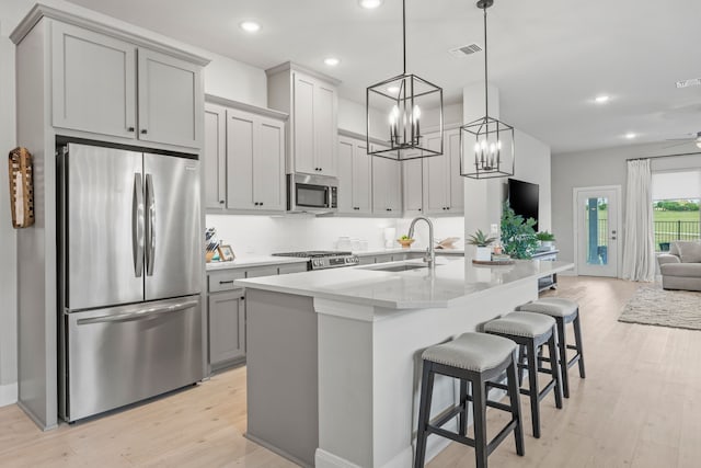 2102 Clearwater Way, Royse City, TX 75189 - kitchen with stainless steel appliances, light wood-style flooring, open floor plan, recessed lighting, and gray cabinetry