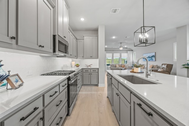 2102 Clearwater Way, Royse City, TX 75189 - kitchen featuring stainless steel appliances, open floor plan, gray cabinets, light wood-type flooring, and recessed lighting