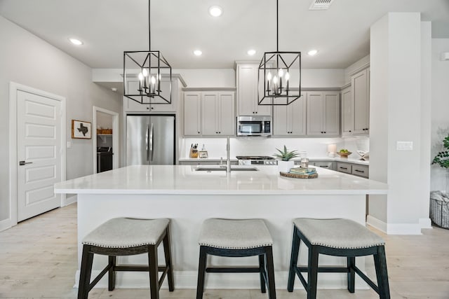 2102 Clearwater Way, Royse City, TX 75189 - kitchen featuring appliances with stainless steel finishes, a chandelier, light wood-style flooring, a center island with sink, and recessed lighting