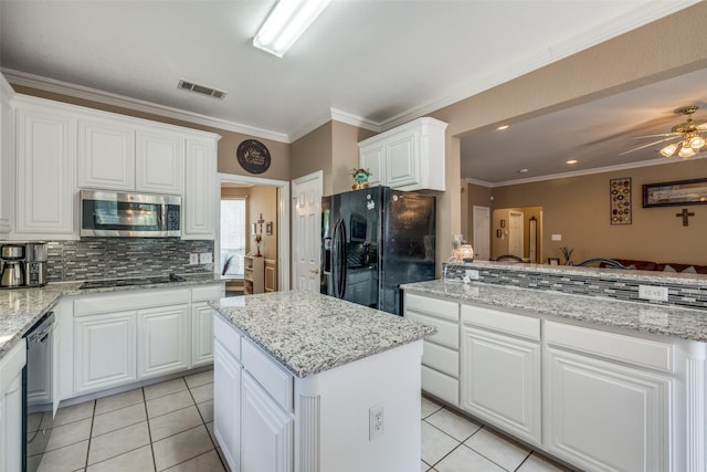 701 Parkhill Dr, Mansfield, TX 76063 - kitchen featuring black appliances, a kitchen island, light tile patterned floors, backsplash, and ornamental molding