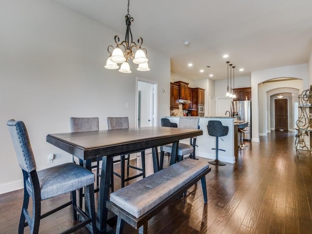 1314 Greenrock Ct, Midlothian, TX 76065 - dining area with arched walkways, a chandelier, recessed lighting, and dark wood-type flooring