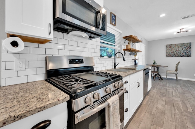 4716 Everest Dr, Fort Worth, TX 76132 - kitchen with appliances with stainless steel finishes, white cabinetry, open shelves, decorative backsplash, and recessed lighting