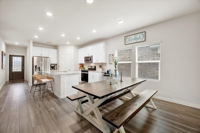 5223 Amistad Ave, Royse City, TX 75189 - kitchen featuring appliances with stainless steel finishes, an island with sink, a breakfast bar, white cabinets, and recessed lighting