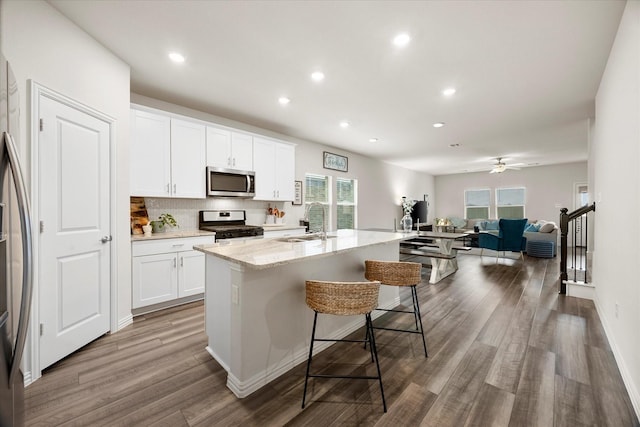 5223 Amistad Ave, Royse City, TX 75189 - kitchen with stainless steel microwave, range with gas stovetop, a kitchen island with sink, tasteful backsplash, and open floor plan