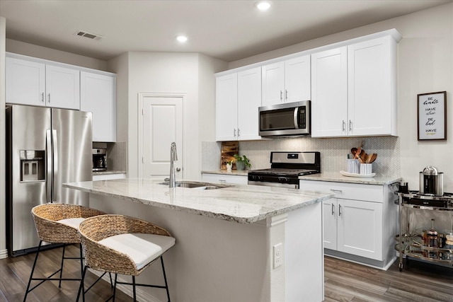 5223 Amistad Ave, Royse City, TX 75189 - kitchen featuring appliances with stainless steel finishes, a kitchen bar, backsplash, an island with sink, and white cabinetry